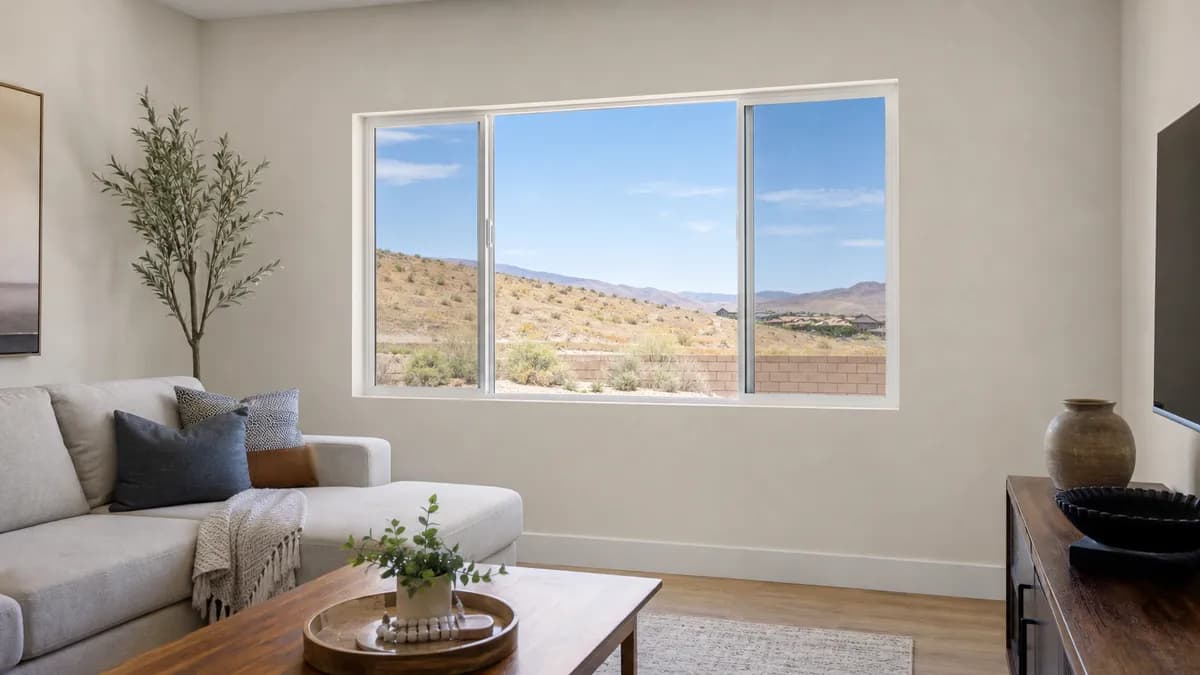 Living room with a wide horizontal sliding window and dry hills visible outside